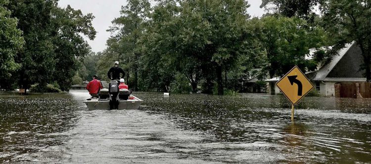 rescuers on boat on flooded street