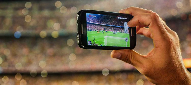 Holding mobile phone to take photo in stadium