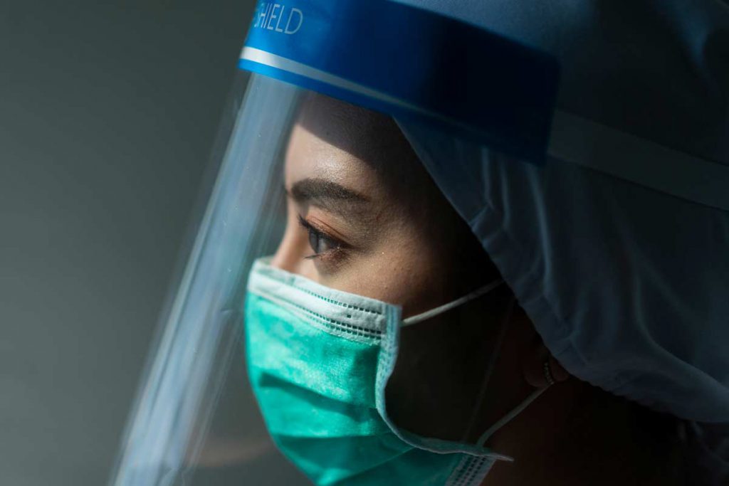 Healthcare worker wearing PPE and face shield